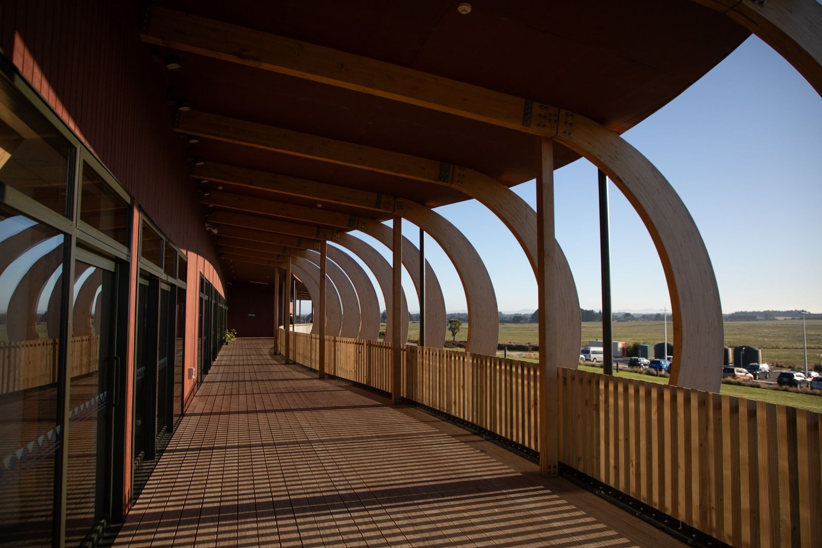 Sunlit veranda walkway beneath the timber arches